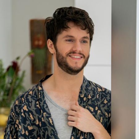 james as forty on You, wearing a robe leaning on a pillar 